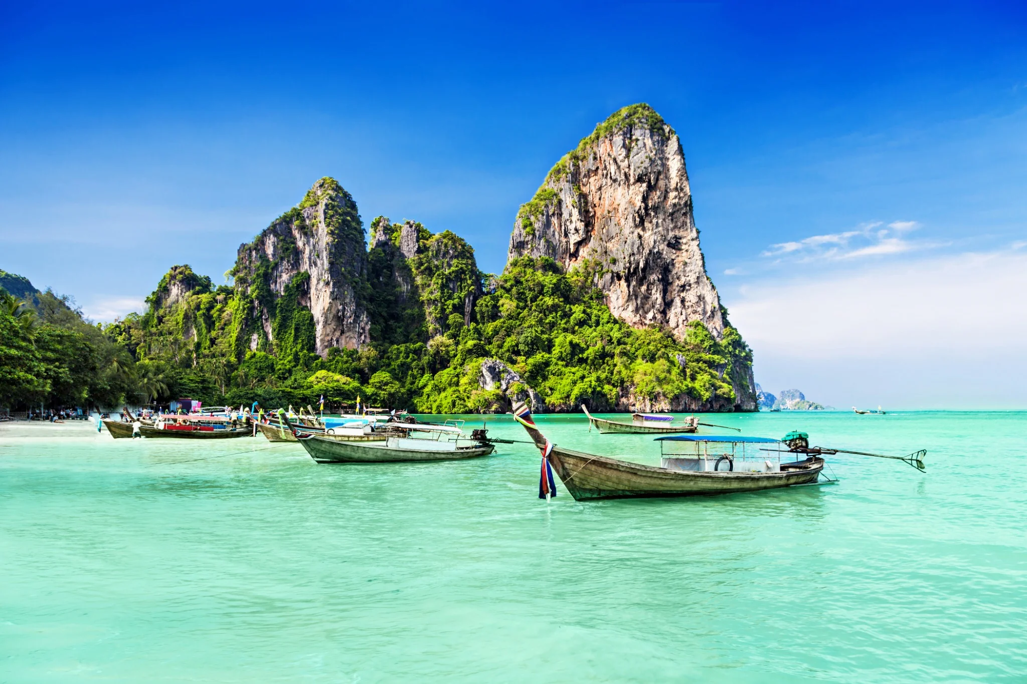 Long-tail boats and turquoise water along Thailand’s limestone coast